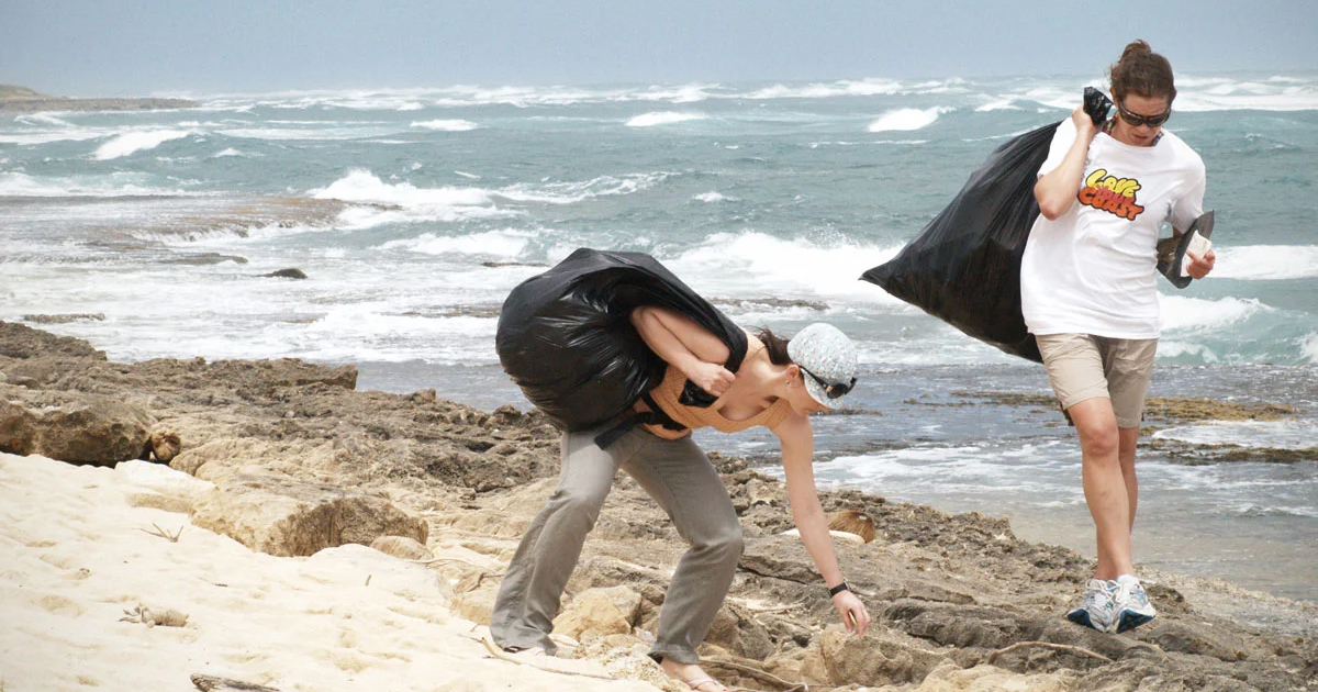 People picking up trash on the beach